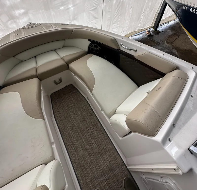 Slide: The Image of 2012 Regal 2700 Bowrider interior with beige and white seating, carpeted floor. - 20