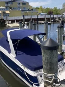 Slide: The Image of 2012 Regal 2700 Bowrider docked, featuring a blue canopy and sleek design. - 3