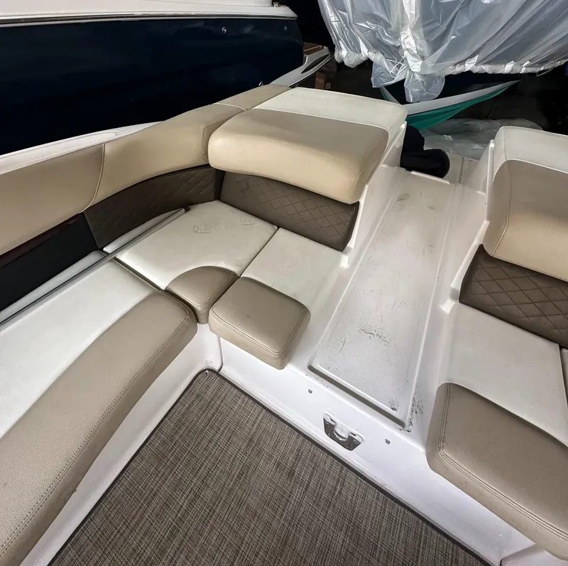 Slide: The Image of 2012 Regal 2700 Bowrider interior seating with beige upholstery and carpeted flooring. - 7