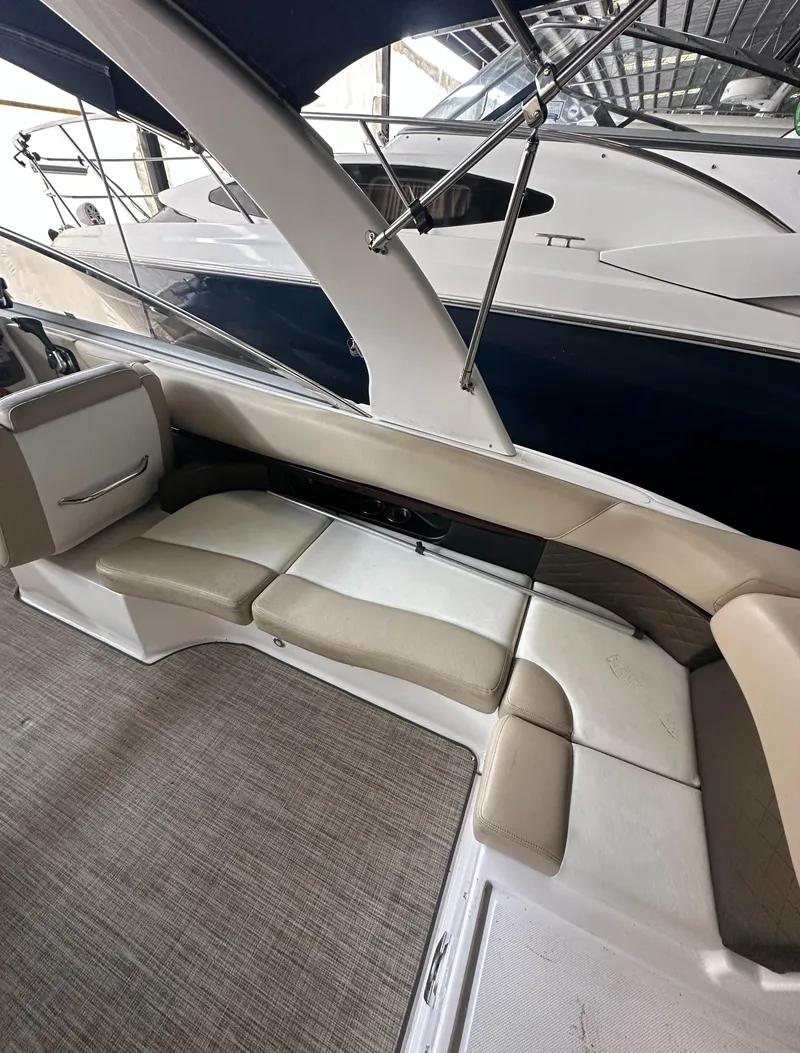 Slide: The Image of 2012 Regal 2700 Bowrider interior with beige seating and carpeted flooring. - 9