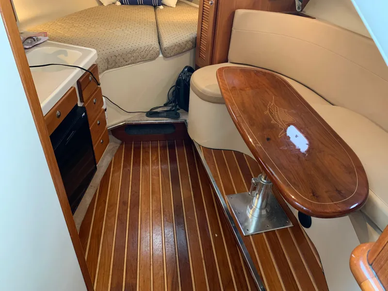 Slide: The Image of 2007 Pursuit OS 335 cabin interior with wood flooring, kitchenette, and seating area. - 14