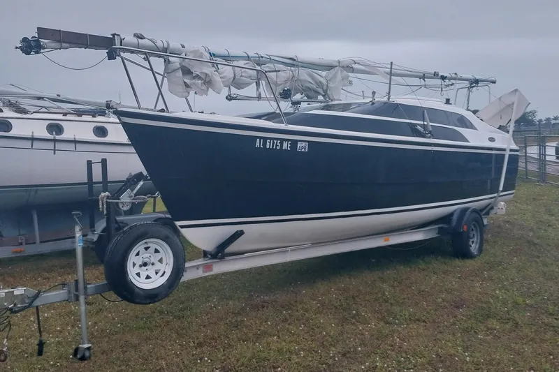 Slide: The Image of 2012 MacGregor 26M sailboat on trailer, parked on grass. - 1