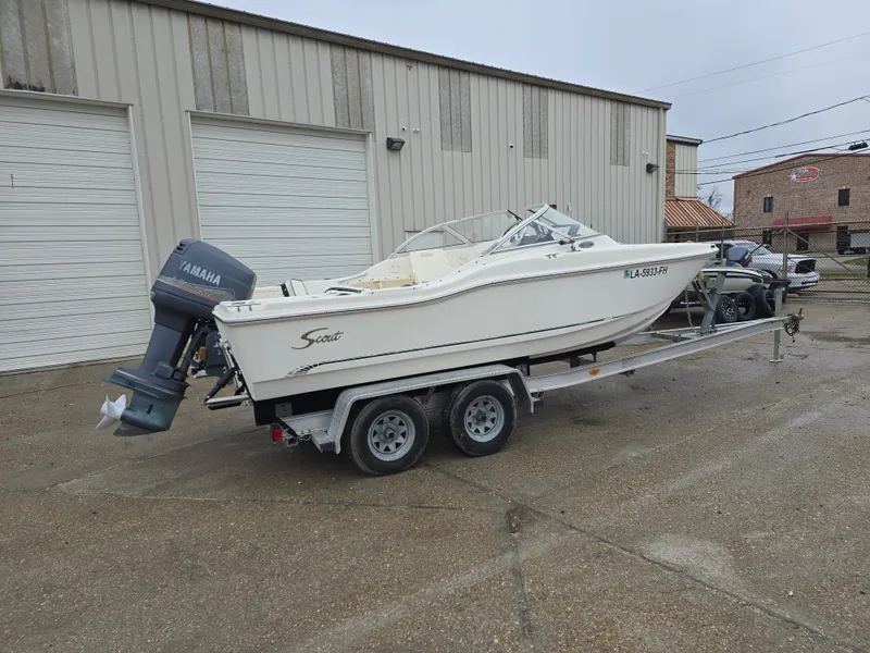 Slide: The Image of 2003 Scout 202 Dorado boat on trailer with Yamaha outboard motor, parked outside warehouse. - 2