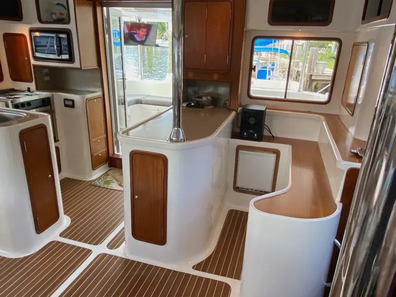 Slide: The Image of 2013 Africat PowerCat Sportfisher interior with modern kitchen and wood accents. - 11
