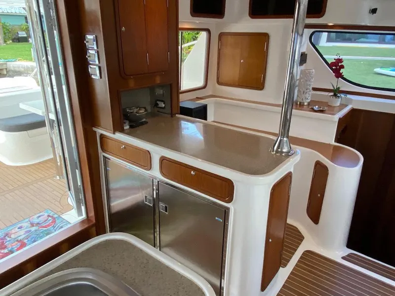 Slide: The Image of Interior of 2013 Africat PowerCat Sportfisher, featuring modern kitchen with wood accents and stainless appliances. - 12