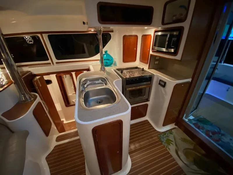 Slide: The Image of 2013 Africat Marine AfriCat PowerCat Sportfisher kitchen interior with sink, stove, and microwave. - 29
