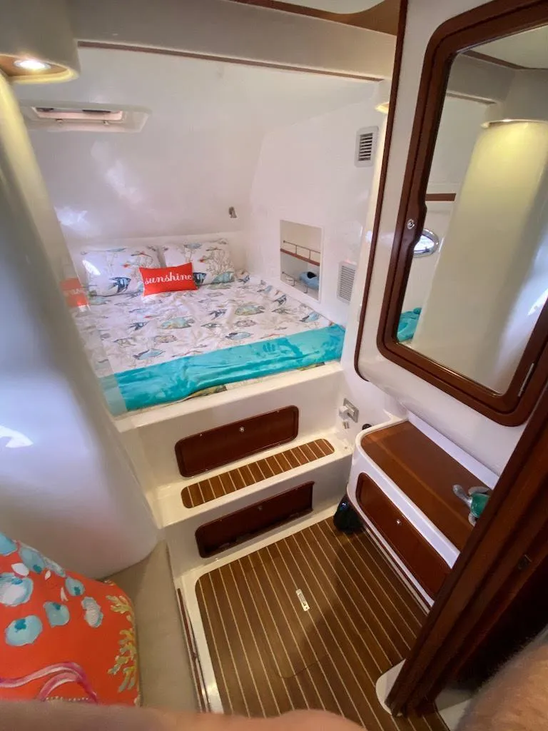 Slide: The Image of 2013 Africat PowerCat Sportfisher cabin with bed, wooden flooring, and mirror. - 36