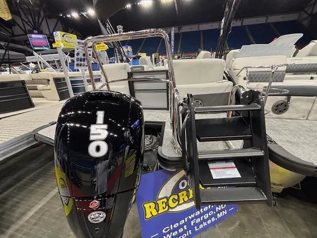 Slide: The Image of 2025 Harris Cruiser 230 boat with 150 HP engine at a boat show display. - 13