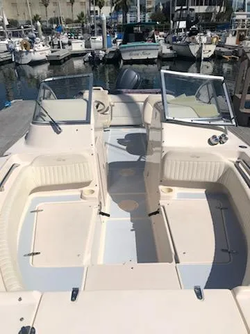 Slide: The Image of 2005 Grady-White Tournament 225 boat docked at a marina, featuring open seating and dual consoles. - 10