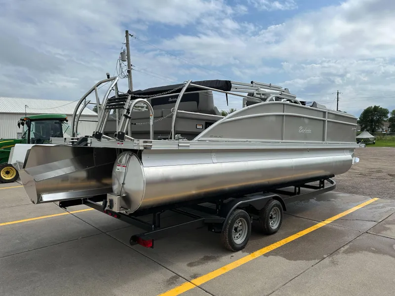 Slide: The Image of 2025 Barletta Aria 24UC pontoon boat on trailer, parked outdoors. - 29