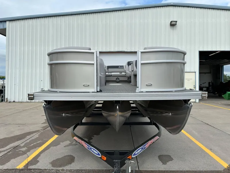 Slide: The Image of 2025 Barletta Aria 24UC pontoon boat parked outside a warehouse. - 7