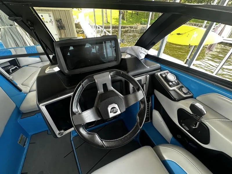 Slide: The Image of 2021 Malibu M220 boat interior with steering wheel and dashboard controls. - 12