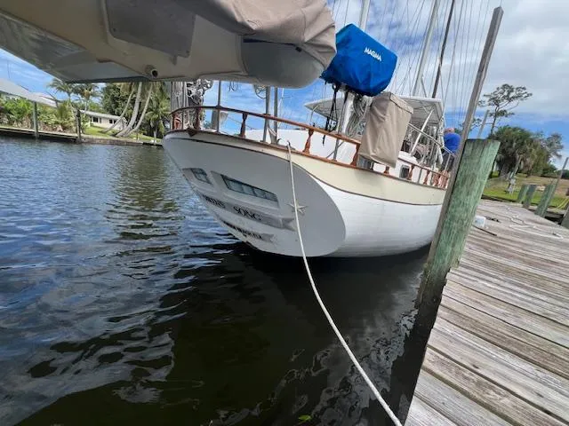 Slide: The Image of 1981 Hardin Voyager 45 Ketch docked by a wooden pier, calm water, and clear sky. - 10