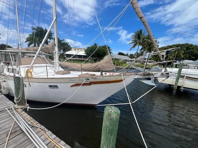 Slide: The Image of 1981 Hardin Voyager 45 Ketch docked, featuring classic design and rigging. - 11