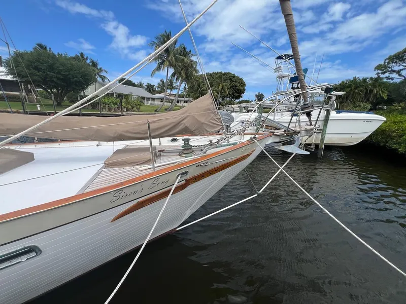 Slide: The Image of 1981 Hardin Voyager 45 Ketch docked, showcasing elegant design and rigging under a clear sky. - 17