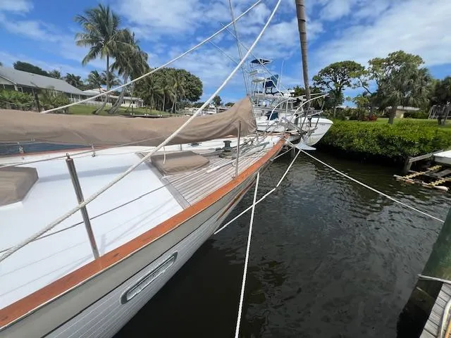 Slide: The Image of 1981 Hardin Voyager 45 Ketch docked, surrounded by lush greenery and clear blue skies. - 19