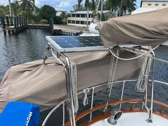 Slide: The Image of 1981 Hardin Voyager 45 Ketch with solar panel, docked near palm trees. - 20