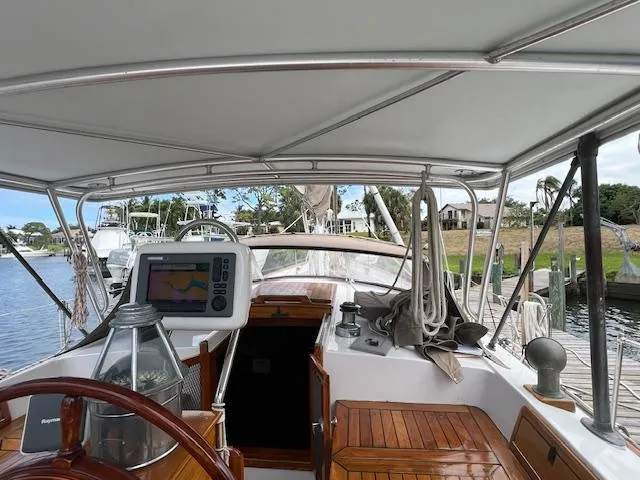 Slide: The Image of 1981 Hardin Voyager 45 Ketch cockpit with navigation equipment and wooden details at a marina. - 30
