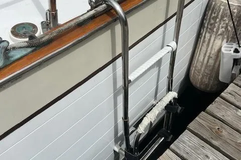 Slide: The Image of Stainless steel ladder on 1981 Hardin Voyager 45 Ketch, docked beside wooden pier. - 32