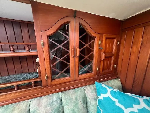 Slide: The Image of Wooden interior of 1981 Hardin Voyager 45 Ketch with glass cabinet and teal cushion. - 46
