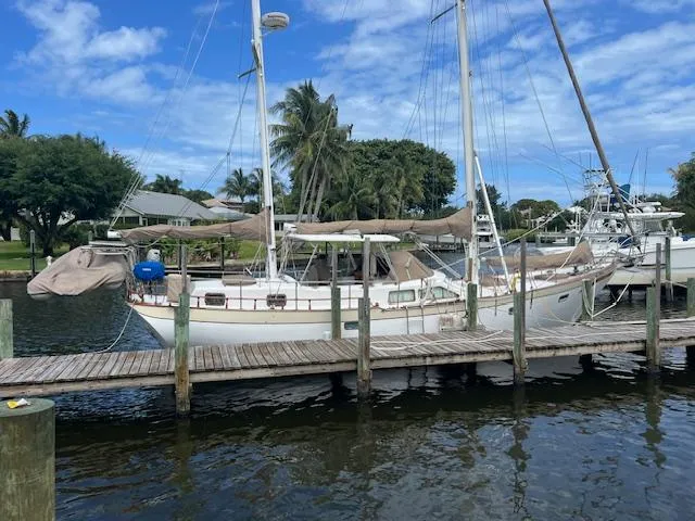Slide: The Image of 1981 Hardin Voyager 45 Ketch docked by palm trees under blue sky. - 5