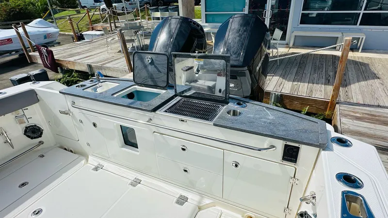 Slide: The Image of 2023 Boston Whaler 360 Outrage boat with outdoor kitchen and dual engines at dock. - 8