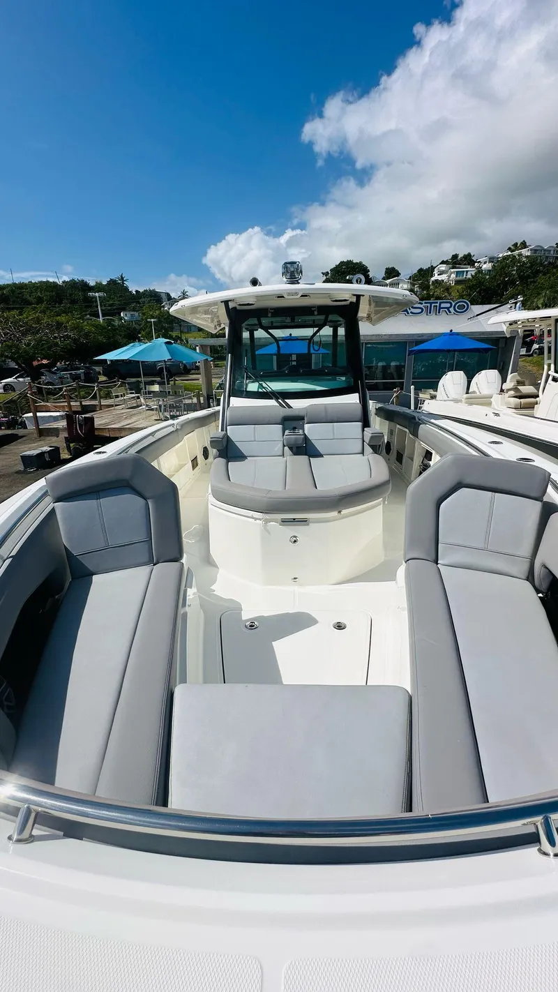 Slide: The Image of 2023 Boston Whaler 360 Outrage boat with spacious seating and sleek design under a clear blue sky. - 9