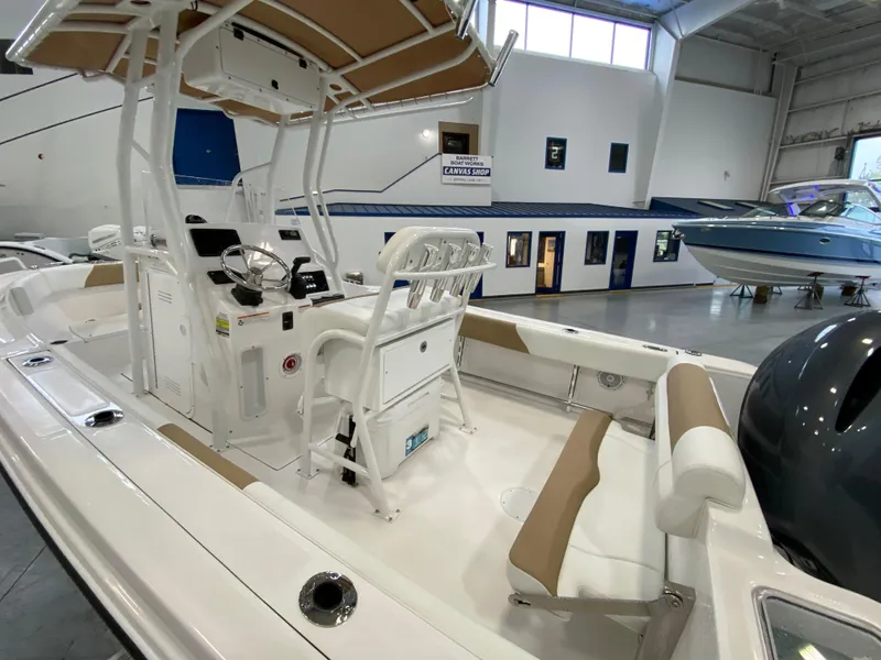 Slide: The Image of 2023 Edgewater 208CC boat interior with seating and console in showroom. - 2
