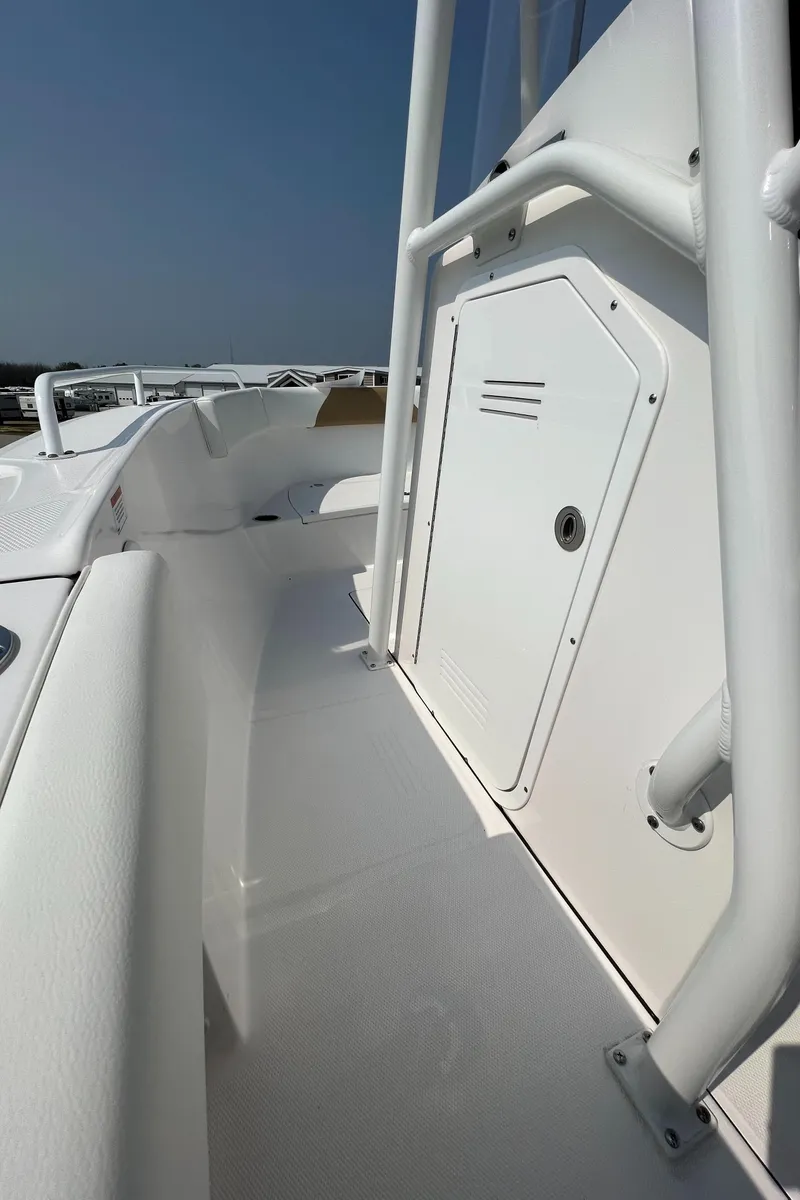 Slide: The Image of 2023 Edgewater 208CC boat deck with white railing and storage compartment. - 20