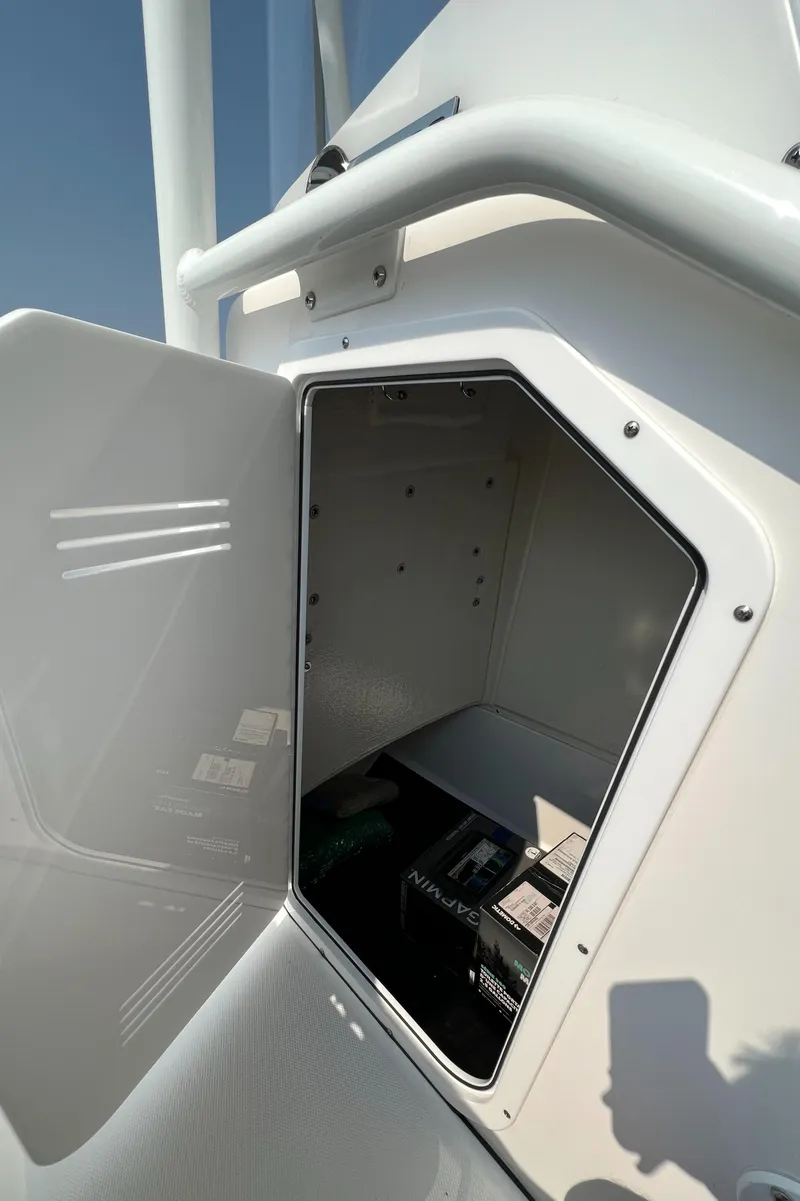 Slide: The Image of Open storage compartment on 2023 Edgewater 208CC boat under clear blue sky. - 21