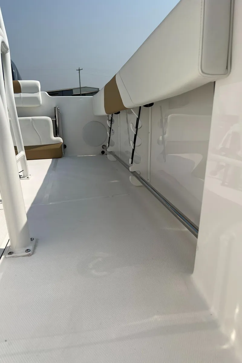 Slide: The Image of 2023 Edgewater 208CC boat interior with white and tan seating, sleek design. - 22