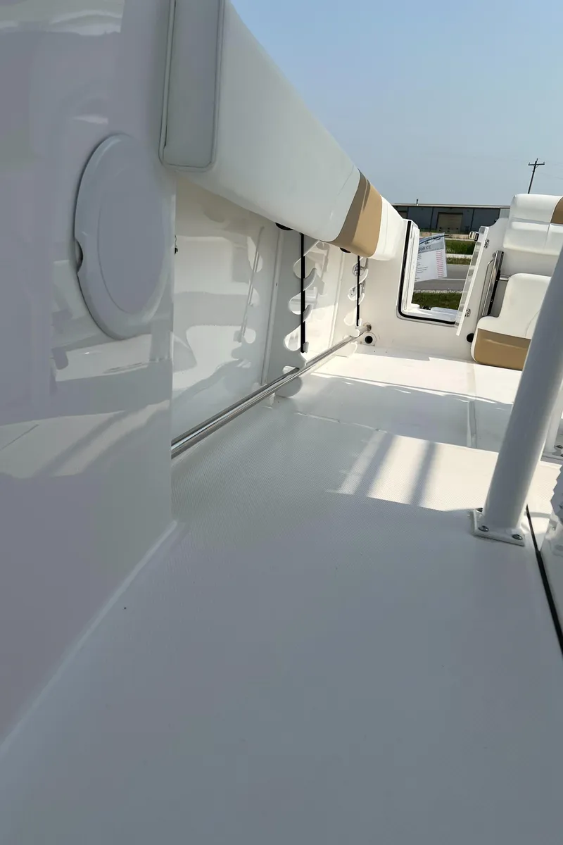 Slide: The Image of 2023 Edgewater 208CC boat interior with sleek white design and cushioned seating. - 23