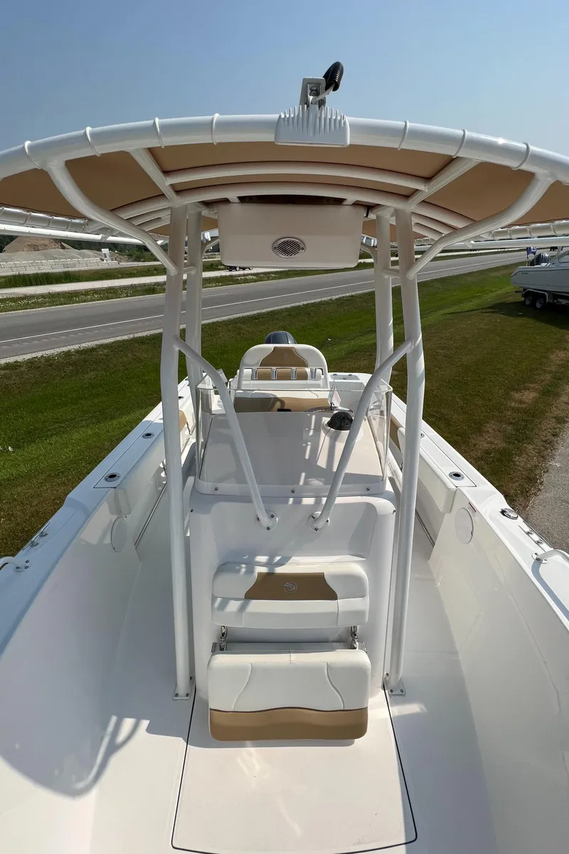 Slide: The Image of 2023 Edgewater 208CC boat with T-top, white interior, and dual seating. - 24