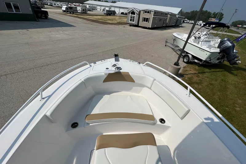 Slide: The Image of 2023 Edgewater 208CC boat interior with tan seating, displayed outdoors. - 26