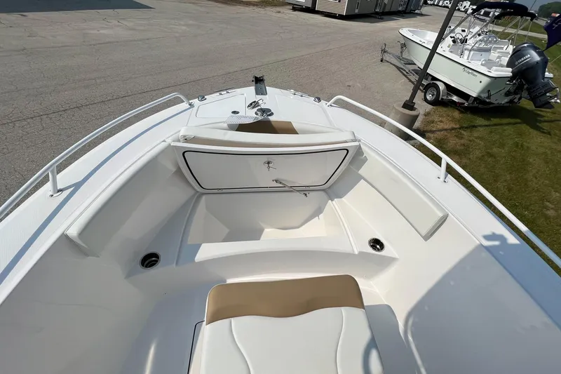 Slide: The Image of 2023 Edgewater 208CC boat interior with seating and storage, displayed outdoors. - 27