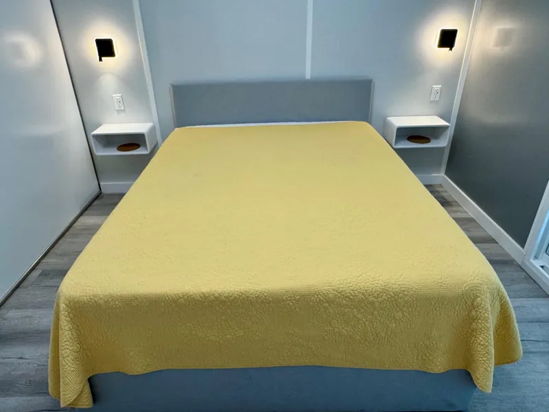 Slide: The Image of Modern bedroom with yellow bedspread, wall sconces, and floating nightstands, Modern Struktures MS 400, 2023. - 18