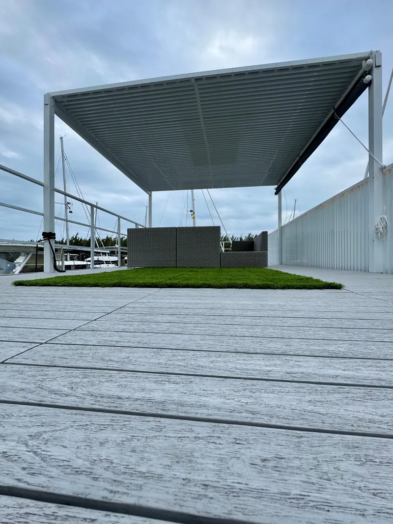 Slide: The Image of Modern Struktures MS 400 pergola on a wooden deck, 2023 model, with overcast sky. - 23