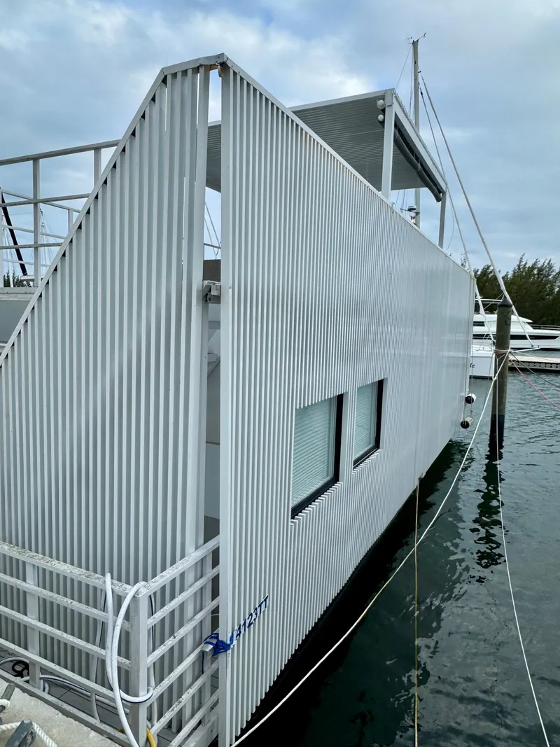 Slide: The Image of Modern Struktures MS 400 houseboat, 2023 model, docked with sleek, corrugated exterior design. - 24