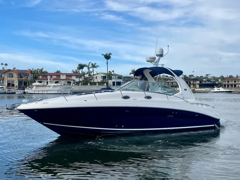 Slide: The Image of 2006 Sea Ray 320 Sundancer cruising in a scenic marina setting. - 0