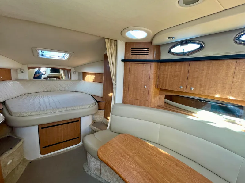 Slide: The Image of Interior of 2006 Sea Ray 320 Sundancer, featuring cozy seating and a comfortable bed. - 15