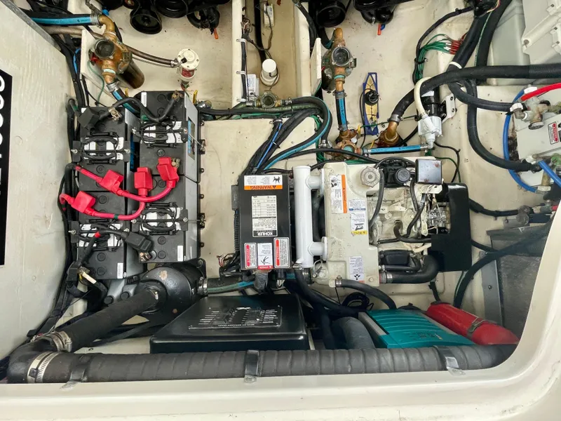 Slide: The Image of Engine compartment of 2006 Sea Ray 320 Sundancer, showcasing batteries and mechanical components. - 35