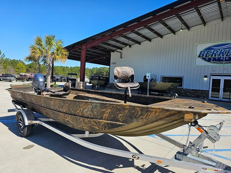 Slide: The Image of 2025 G3 Gator Tough 18 DK boat on trailer, camo design, parked outside dealership. - 2