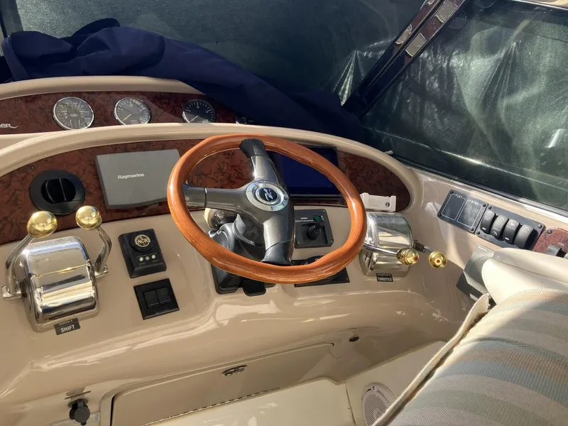 Slide: The Image of 2004 Sea Ray 460 Sundancer helm with wood steering wheel and control panel. - 10