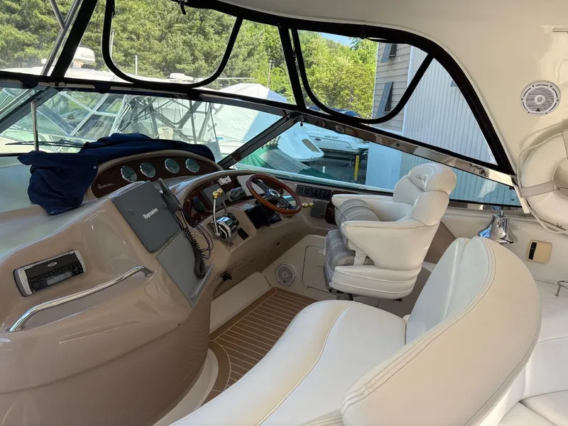 Slide: The Image of 2004 Sea Ray 460 Sundancer helm with white seating and modern controls. - 15