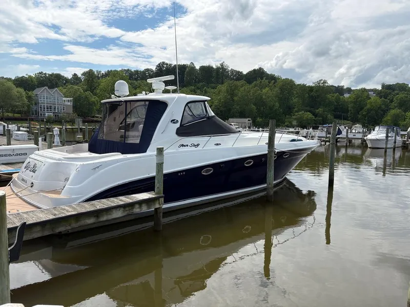 Slide: The Image of 2004 Sea Ray 460 Sundancer yacht docked at a marina with lush greenery. - 2