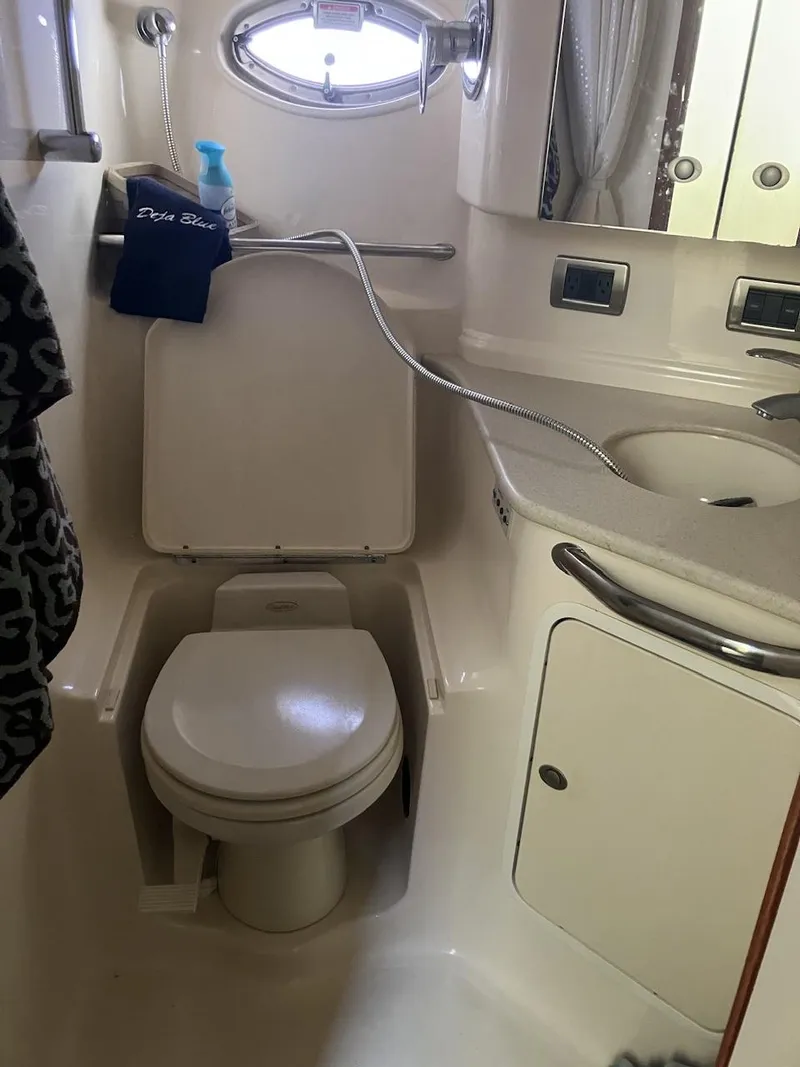 Slide: The Image of 2004 Sea Ray 460 Sundancer bathroom with toilet, sink, and porthole window. - 23