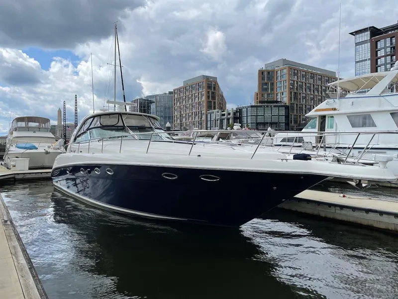 Slide: The Image of 2004 Sea Ray 460 Sundancer yacht docked in a marina, with modern buildings in the background. - 3