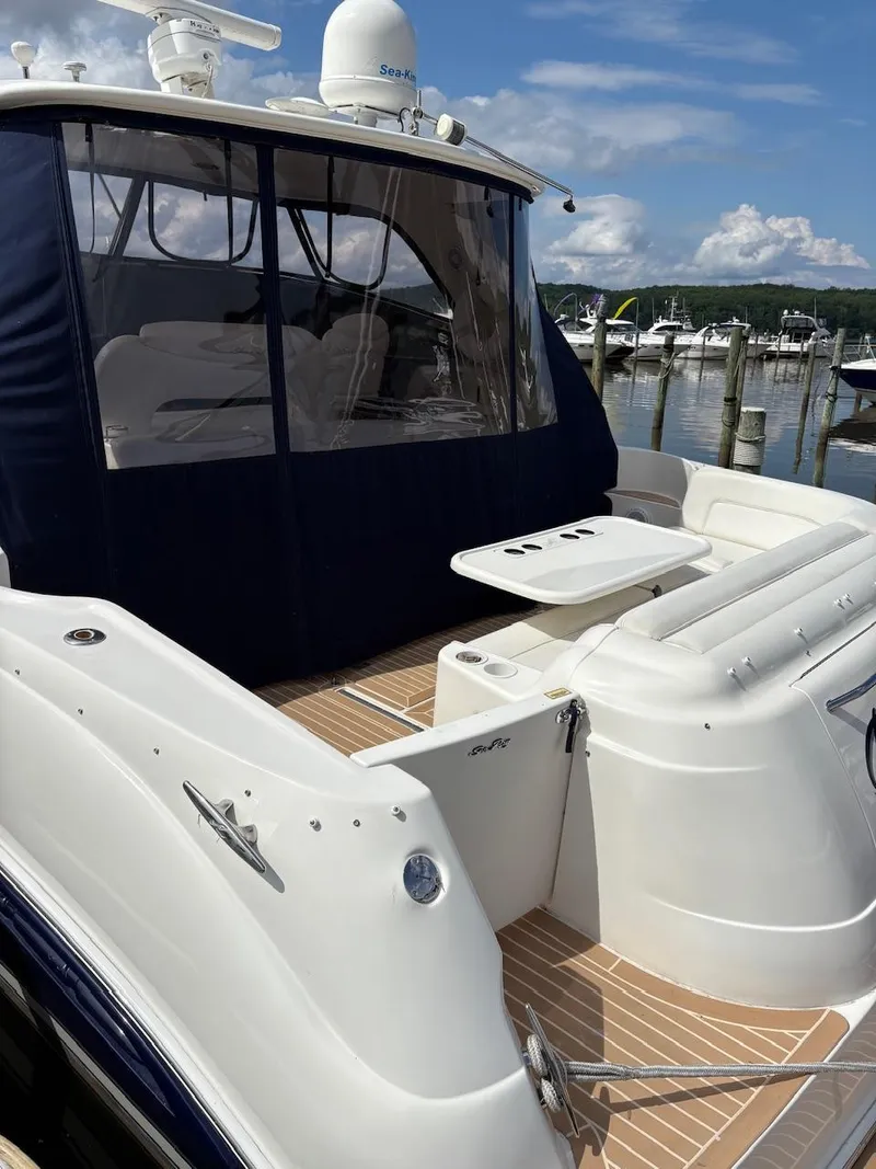 Slide: The Image of 2004 Sea Ray 460 Sundancer yacht docked at marina, featuring spacious deck and seating area. - 30