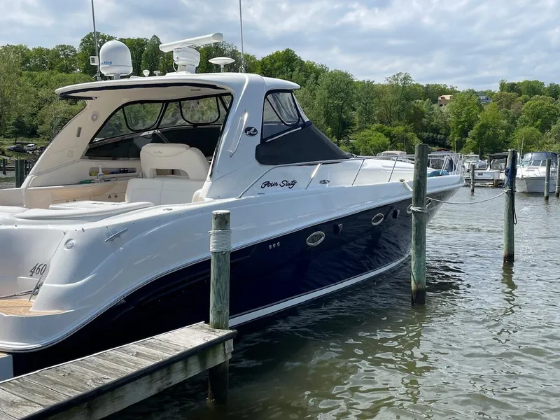 Slide: The Image of 2004 Sea Ray 460 Sundancer yacht docked on a serene lake with lush greenery. - 4