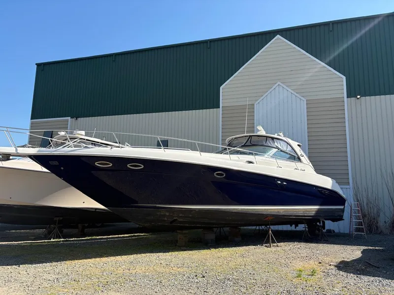 Slide: The Image of 2004 Sea Ray 460 Sundancer yacht docked near a large warehouse. - 6